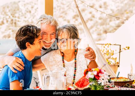 Fröhliche glückliche Familie feiern zusammen beim Mittagessen Umarmung und Lächeln - gemischte Generationen Alter mit Großvätern und kaukasischen Teenager Enkel - SoC Stockfoto