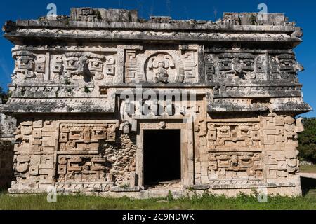 Die kunstvoll geschnitzte Fassade des Nonnenkomplexes mit mehreren Chaac-Masken in den Ruinen der großen Maya-Stadt Chichen Itza, Yucatan, Mexiko. Stockfoto