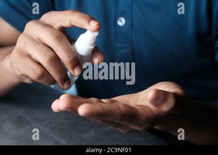 Nahaufnahme der Hand eines jungen Mannes mit Handdesinfektionsspray. Stockfoto