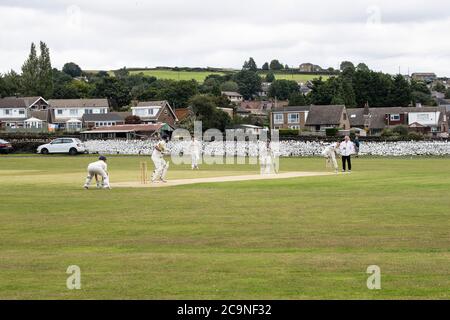 Blick auf ein Dorf Cricket Spiel am Samstagnachmittag in Kirkheaton Village in West Yorkshire, England Stockfoto