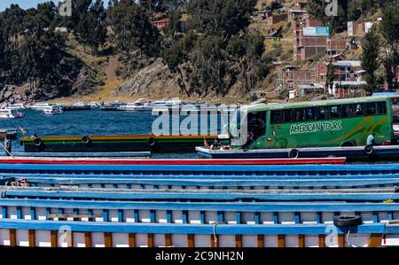 SAN PEDRO DE TIQUINA, BOLIVIEN - 23. JULI 2016: Ein Touristenbus wird auf einem Holzfloß im Titicacasee, Bolivien, gefahren Stockfoto