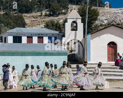 ISLA DEL SOL, BOLIVIEN - 26. JULI 2016: Eine Gruppe bolivianischer Mädchen tanzt in typischen Kostümen bei einem traditionellen Fest neben einer Kirche Stockfoto