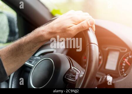 Männliche Hände halten Auto Lenkrad. Die Hände am Lenkrad eines Autos  fahren in der Nähe des Palm. Mann, der ein Auto innen Kabine. Multimedia  System Isola Stockfotografie - Alamy