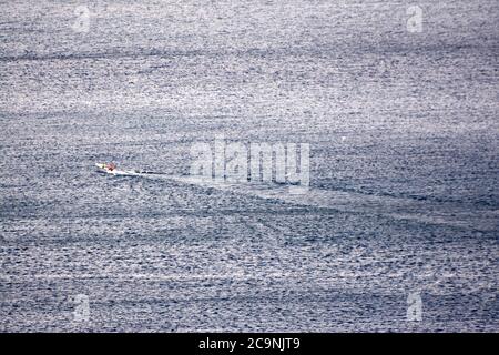 Kleines Boot auf ruhiger flacher Oberfläche des Ozeans Stockfoto