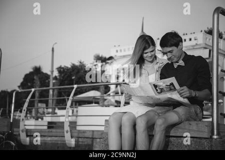 ODESSA, UKRAINE - 06. AUGUST 2015: Nahaufnahme eines glücklichen jungen Paares auf dem Holzdeck im Hafen mit einer Karte in den Händen, Reisekonzept Stockfoto