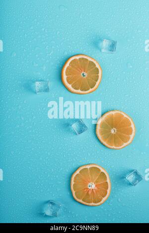 Scheiben von frischem Orange auf blauem Hintergrund mit Eis. Stockfoto