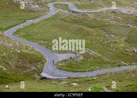 Healy Pass, Cork, Irland. August 2020. Ein einsame Radler macht sich auf die steile, gewundene Straße zum Gipfel des Healy Pass, Co. Cork, Irland. - Credit; David Creedon / Alamy Live News Stockfoto