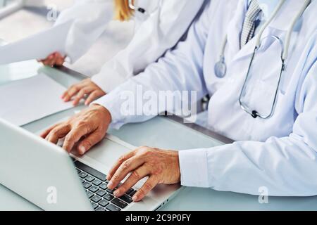 Das Medical Doctor Team diskutiert über Konferenz zur gemeinsamen Untersuchung des Patient Medical Report im Untersuchungsraum. Ärzte Stockfoto
