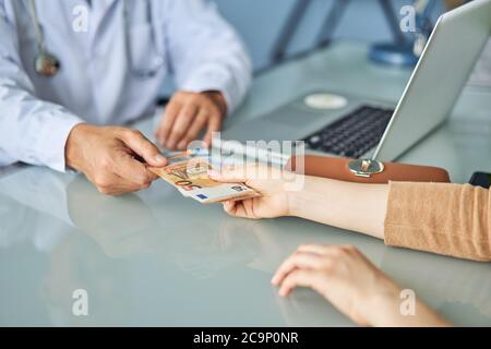 Zahlung an einen Arzt für die medizinische Versorgung. Bezahlte Medizin Konzept. Stockfoto