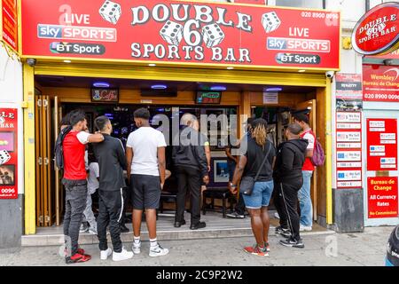 Wembley Park, London, Großbritannien. 1. August 2020Arsenal-Fans, die das Spiel in der Double Six Sports Bar, Wembley Park, beobachten, feiern den Gewinn des FA Cup Finales gegen Chelsea. Das FA Cup Finale wurde von seinem traditionellen Termin im Mai wegen der Coronavirus Covid-19 Pandemie verschoben. Aufgrund der anhaltenden Einschränkungen war dies das erste FA Cup Finale in seiner Geschichte, das in einem leeren Stadion stattfand, da keine Fans zugelassen waren. Amanda Rose/Alamy Live News Stockfoto