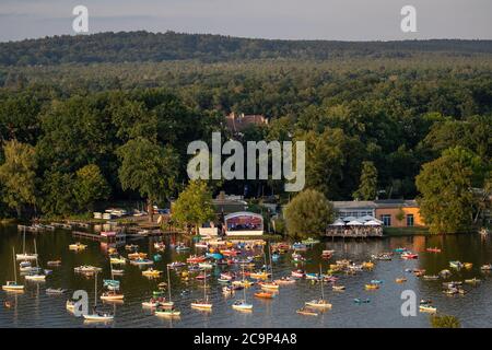 01. August 2020, Bayern, Nürnberg: Die Staatsphilharmonie (h, M) spielt auf der Seestufe auf dem Großen Dutzendteich ein Konzert vor Zuschauern, die das Konzert auf eigenen Booten verfolgen. Aufgrund der musikalischen Veranstaltungen Bardentreffen, Klassik Open Air und Stars in Luitpoldhain, die aufgrund von Corona abgesagt wurden, hat das Projektbüro im Kulturbereich der Stadt Nürnberg drei verschiedene Konzerte mit einem Open-Air-Konzertwochenende am Ufer des Dutzendteichs organisiert. Das einzigartige Angebot soll als Brückenhilfe und Experiment in einem dienen. Das Publikum wird ihr o mitbringen müssen Stockfoto