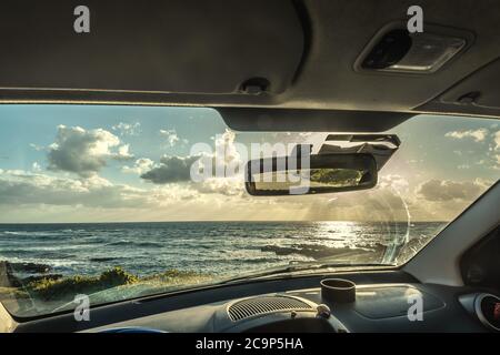 Auto geparkt am Meer bei Sonnenuntergang in Sardinien, Italien Stockfoto