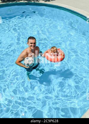 Budva, Montenegro - 01. august 2020: Vater und Tochter schwimmen im Pool. Stockfoto