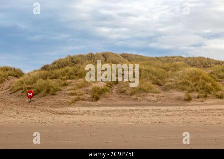 Blick zurück vom Meer in Richtung Marram Gras bewachsenen Sanddünen und einem Rettungsgürtel, bei Formby in Merseyside Stockfoto