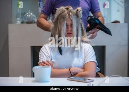 Ein Mädchen hat ihr Haar von ihrem Friseur zu Hause getrocknet Stockfoto