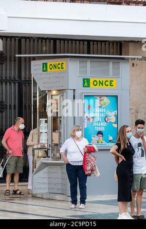 Punta Umbria, Huelva, Spanien - 11. Juli 2020: Mann in Schutzmaske kauft Lotteriekarten an einem ONCE Kiosk in Punta Umbria, Andalusien, Spanien Stockfoto