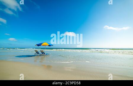 Strandliegen und Sonnenschirm im weltberühmten Daytona Beach. Florida, USA Stockfoto