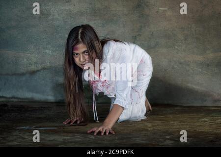 Zombie Frau kriecht auf dem Boden mit blutigem, halloween-Konzept Stockfoto