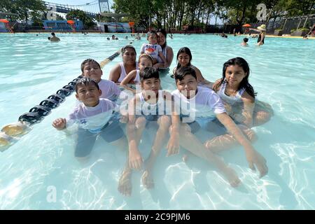New York City, USA. August 2020. Mitglieder der Familie Ortega sitzen am Eröffnungstag im Außenpool des Astoria Park, der wegen der Pandemie COVID-19 im Stadtteil Queens von New York, NY, am 1. August 2020 geschlossen war. Das New York City Parks Department eröffnete heute sieben weitere öffentliche Pools im Rahmen der Phase IV Wiedereröffnung, mit insgesamt fünfzehn in den fünf Bezirken, wo Masken benötigt werden, außer im Pool selbst, und beobachtete soziale Distanzierung so gut wie möglich. (Anthony Behar/Sipa USA) Quelle: SIPA USA/Alamy Live News Stockfoto