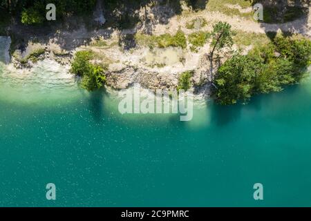 Wald und Kalksteinbruch Seeufer. Küstenansicht von fliegenden Drohne Stockfoto