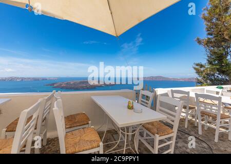 Die Terrasse mit Meerblick im Restaurant, Santorini Insel, Griechenland. Schöne Terrasse mit Meerblick, weißen Stühlen, Tischen. Luxusreise, Sommerurlaub Stockfoto