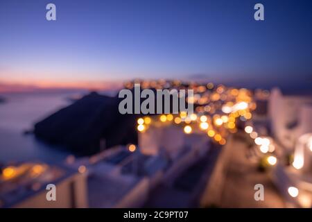 Welt Umwelt Tag Konzept: Bokeh Licht und Unschärfe der Sonnenuntergang Dämmerung Stadt auf Santorini, Griechenland. Meerblick und Insellandschaft, abstraktes Stadtbild Stockfoto