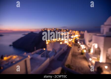 Welt Umwelt Tag Konzept: Bokeh Licht und Unschärfe der Sonnenuntergang Dämmerung Stadt auf Santorini, Griechenland. Meerblick und Insellandschaft, abstraktes Stadtbild Stockfoto