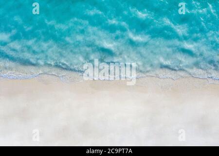 Luftaufnahme von Sandstrand und Meer mit Wellen. Sommer Seestück aus der Luft. Draufsicht von der Drohne. Reisekonzept, Strand und Wellen von oben. Stockfoto