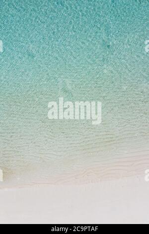 Luftaufnahme von Sandstrand und Meer mit Wellen. Sommer Seestück aus der Luft. Draufsicht von der Drohne. Reisekonzept, Strand und Wellen von oben. Stockfoto