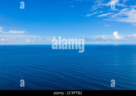 Seascape mit Meereshorizont und fast klaren tiefblauen Himmel Hintergrund. Perfekter Himmel und Wasser, endlose Aussicht auf das Meer, blaue Farbe. Sanfte Wellen, Surfkonzept Stockfoto