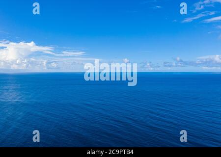 Seascape mit Meereshorizont und fast klaren tiefblauen Himmel Hintergrund. Perfekter Himmel und Wasser, endlose Aussicht auf das Meer, blaue Farbe. Sanfte Wellen, Surfkonzept Stockfoto