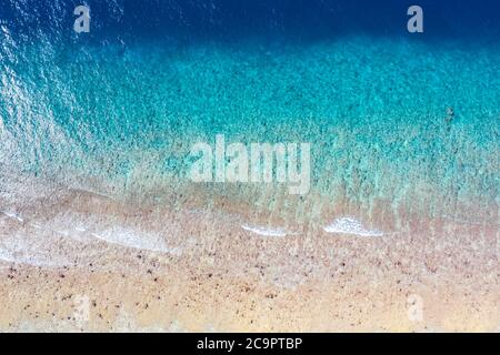 Draufsicht Luftaufnahme von fliegender Drohne. Wunderschöner Strand. Luftaufnahme von ruhigen Wellen, die am Korallenriff brechen. Exotischer Ozeanstrand, tropische Landschaft Stockfoto
