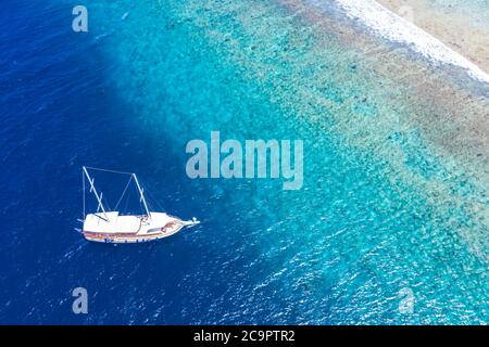 Schöne türkisfarbene Meer Wasser Boot Draufsicht Luftbild. Luftaufnahme Schnellboot im Meer. Exotische Lagune, Schnorchelabenteuer, tropischer Ozean Stockfoto