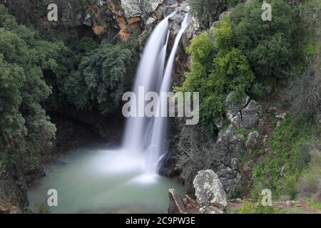 Hoher Wasserfall und Grünflächen rundherum. Langzeitbelichtung. Saar Wasserfall auf den Golanhöhen. Stockfoto