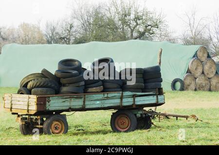 Gebrauchte Reifen liegen auf einem Traktorwagen Stockfoto