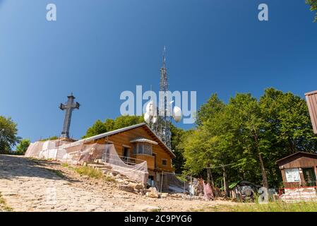 Der Gipfel des Monte amiata und die verschiedenen Wiederholer stellten sie an einem sonnigen Tag mit dem Metallkreuz auf Stockfoto