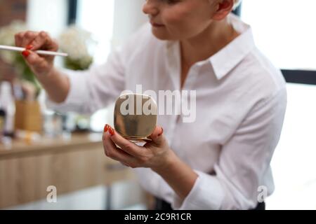 visagist, Make-up-Künstler verwenden Pinsel und dekorative Kosmetik während der Herstellung Make-up auf Modell. Beauty-Konzept Stockfoto