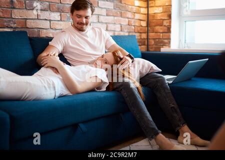 Liebenswert schwangere Frau liegen auf den Knien des Mannes, Rotschopf Frau in der Liebe mit Mann, sie erwarten Baby, junge Familie Stockfoto