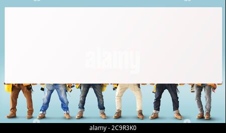 Bauherren mit Werkzeugen in Baukleidung halten eine schwere Platte Stockfoto