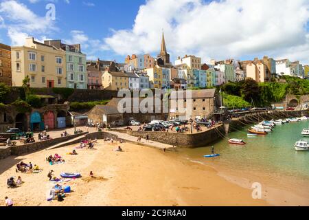 Malerischer Tenby Harbour bei Ebbe gefangen. Ein schöner sonniger Tag, der die bunten Häuser hervorhebt. Stockfoto