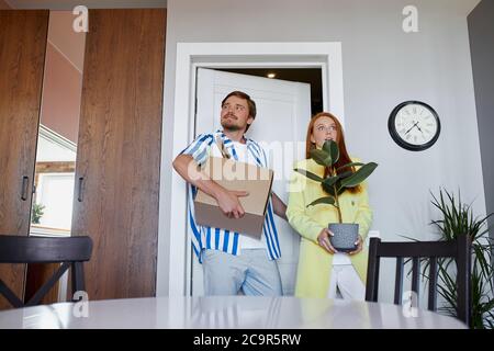 Neu geschaffenen Familie zieht in ihre eigene Wohnung, tragen Boxen und Pflanzen. Umzug, Haus, Wohnung Konzept Stockfoto