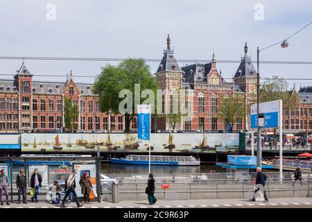 Bahnhof in Amsterdam, Amsterdam Centraal Station oder Hauptbahnhof mit vielen Pendlern und Touristen warten an Bushaltestellen Stockfoto