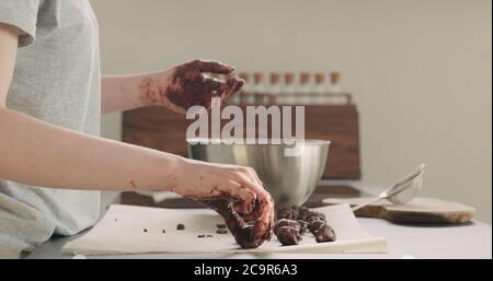 Junge Frau, die Schokoladentrüffel auf heimigeren Kictchen zubereitet Stockfoto