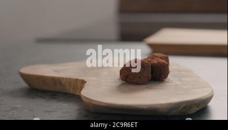 Handgemachte Schokoladentrüffel auf einem Holzbrett Stockfoto