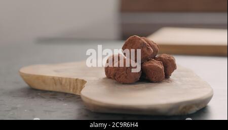 Handgemachte Schokoladentrüffel auf einem Holzbrett Stockfoto