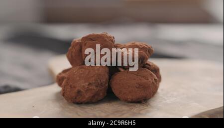 Handgemachte Schokoladentrüffel auf einem Holzbrett Stockfoto