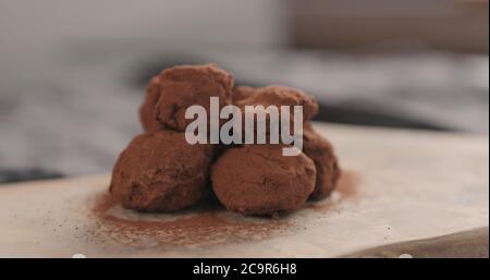 Handgemachte Schokoladentrüffel auf einem Holzbrett Stockfoto