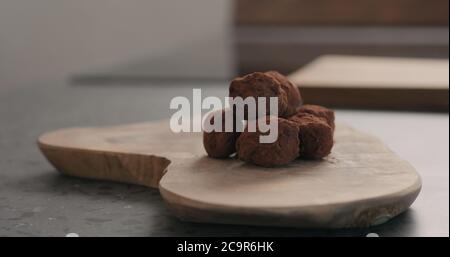 Handgemachte Schokoladentrüffel auf einem Holzbrett Stockfoto