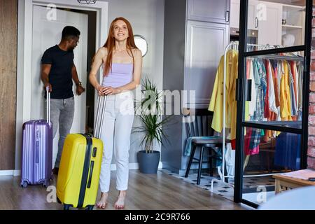 Interracial Paar geben neue Wohnung, junge verheiratete Mann und Frau ziehen in neues Haus zusammen, sie sind glücklich, Schlüssel zu bekommen, tragen Koffer Stockfoto