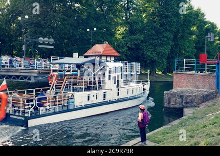 GIZYCKO, MASUREN, POLEN - 22. JULI 2020: Historische Swing Bridge auf Luczanski (Gizycki) Kanal und mittelalterliche Burg der Deutschen Ritter im Hintergrund. Stockfoto